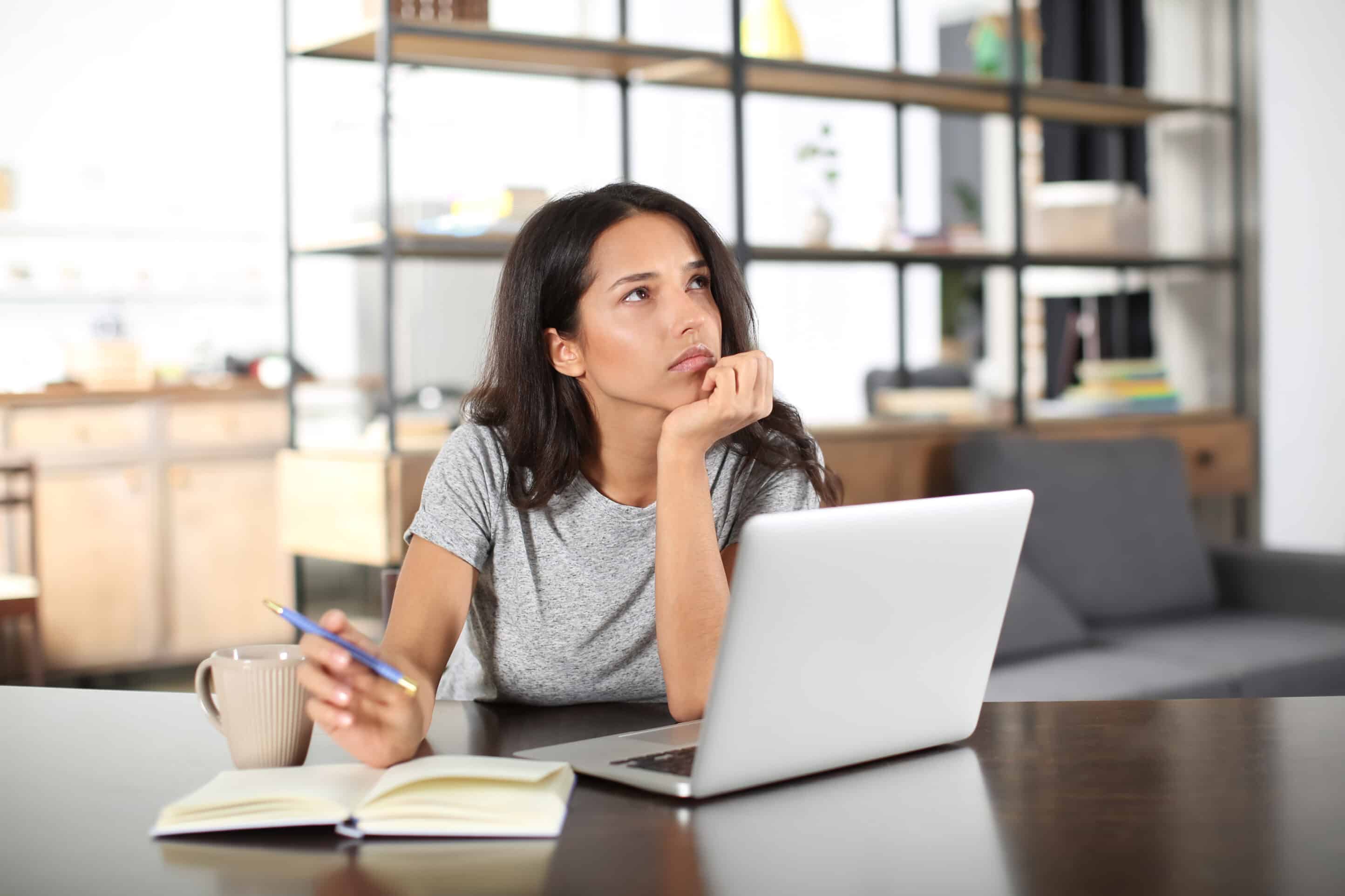 Thoughtful young woman working with laptop at home Thoughtful young woman working with laptop at home